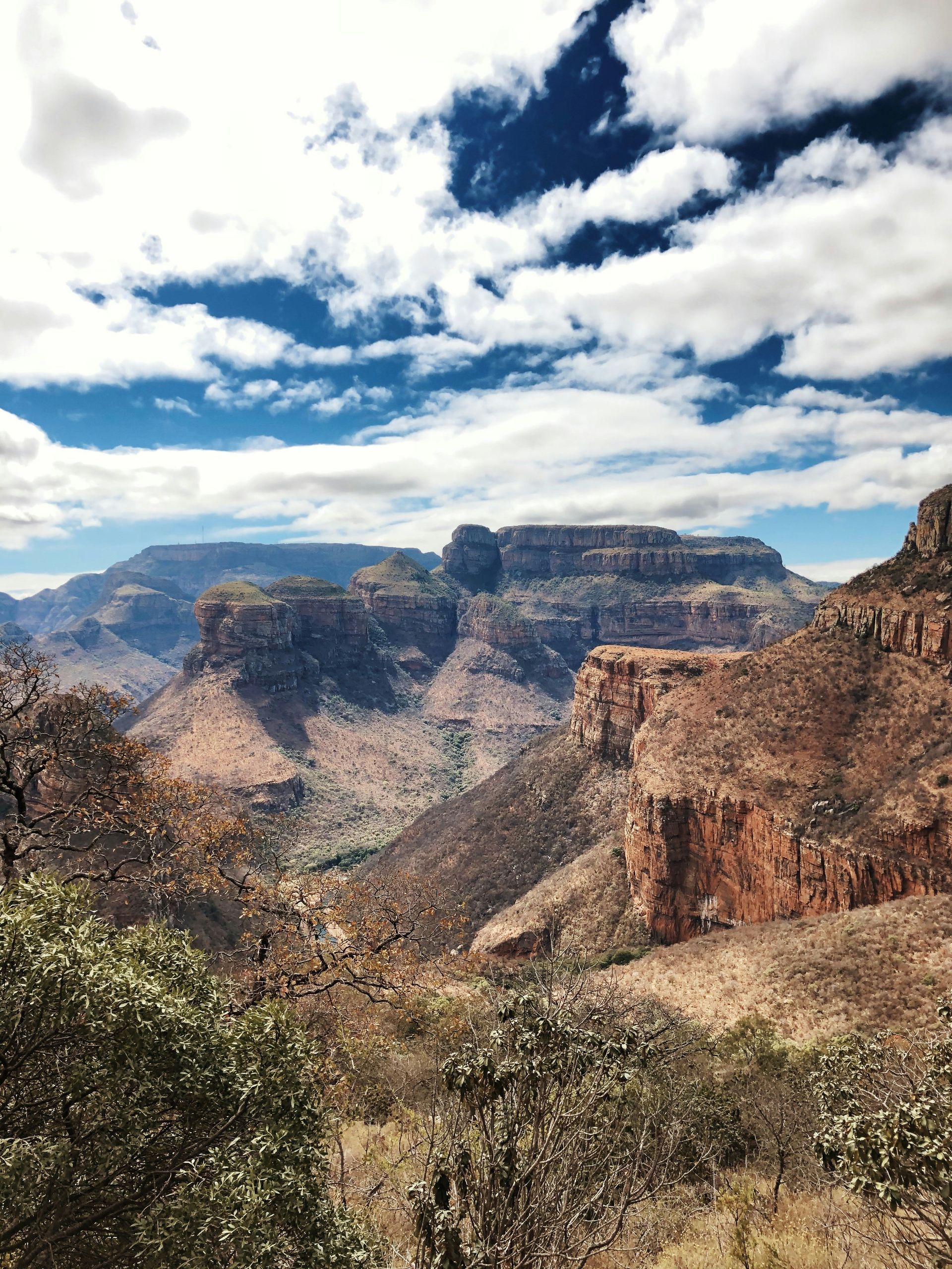 View of a Blyde River Canyon with brown cliffs and lush green valley in South Africa.