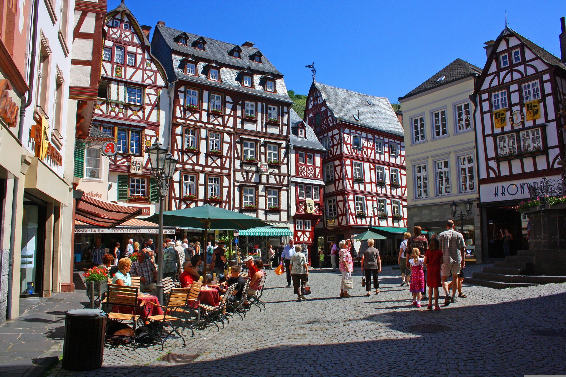 A group of people are walking down a cobblestone street in Bernkastel, Germany.
