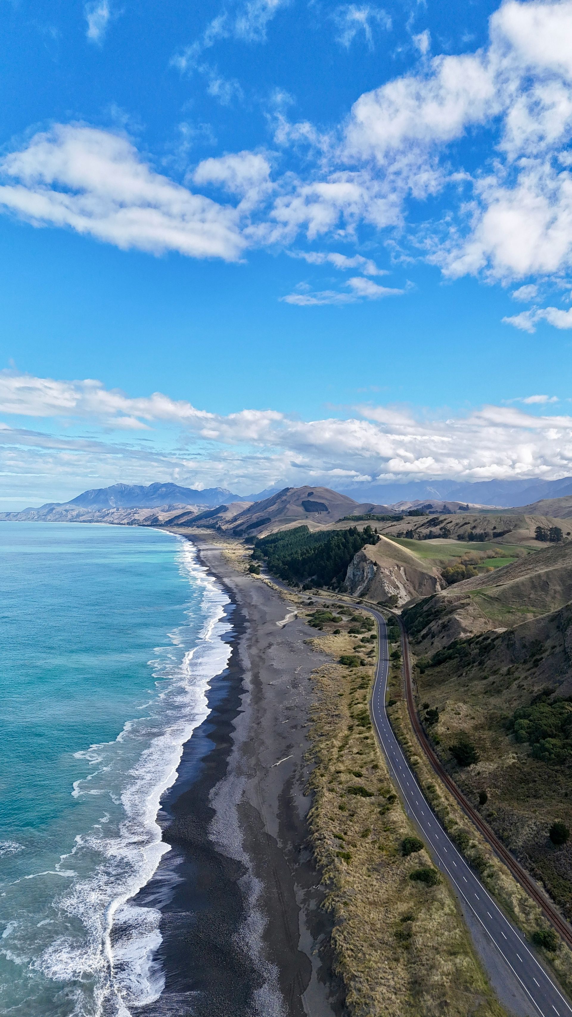 An aerial view of a road leading to the ocean in Kaikōura, New Zealand.