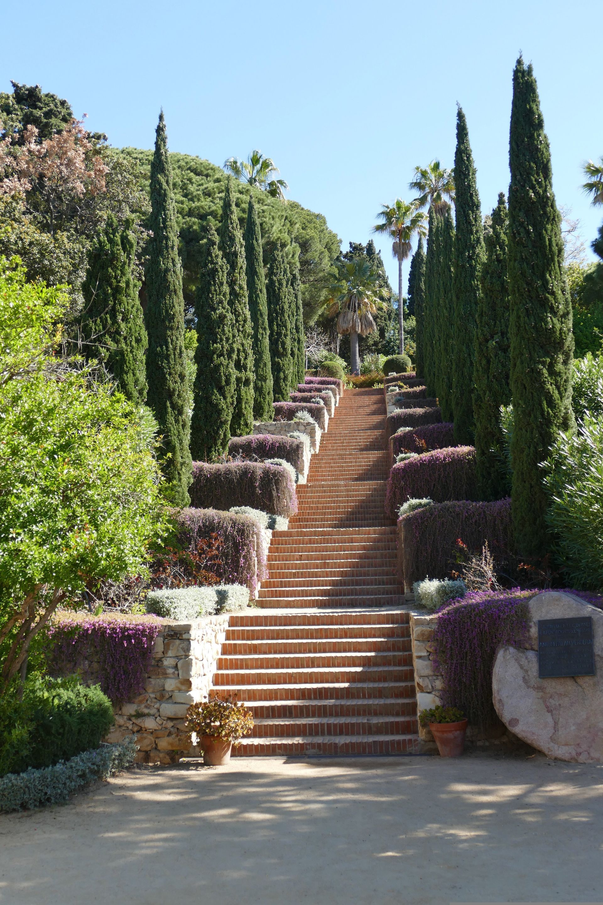 A set of stairs leading up to a lush green forest in Tossa de Mar, Spain.