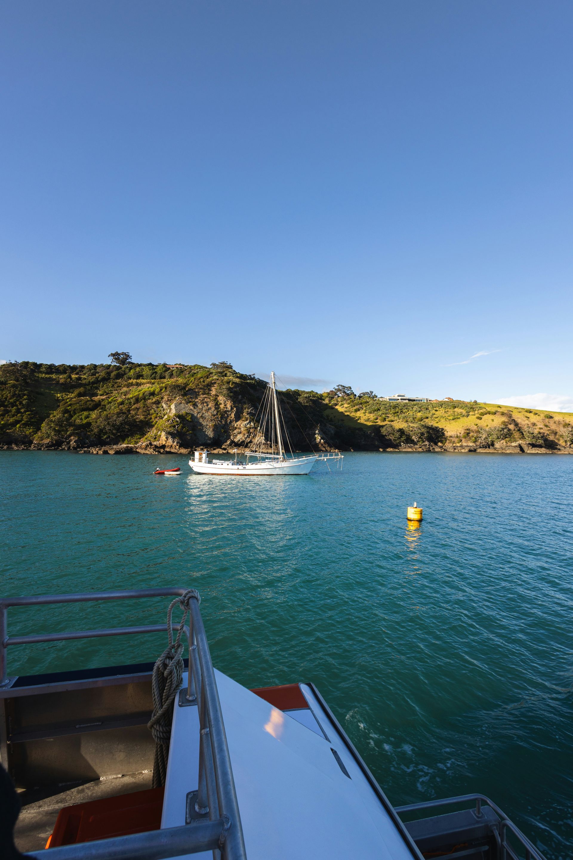 A boat is floating on top of a body of water on Waiheke Island, New Zealand.
