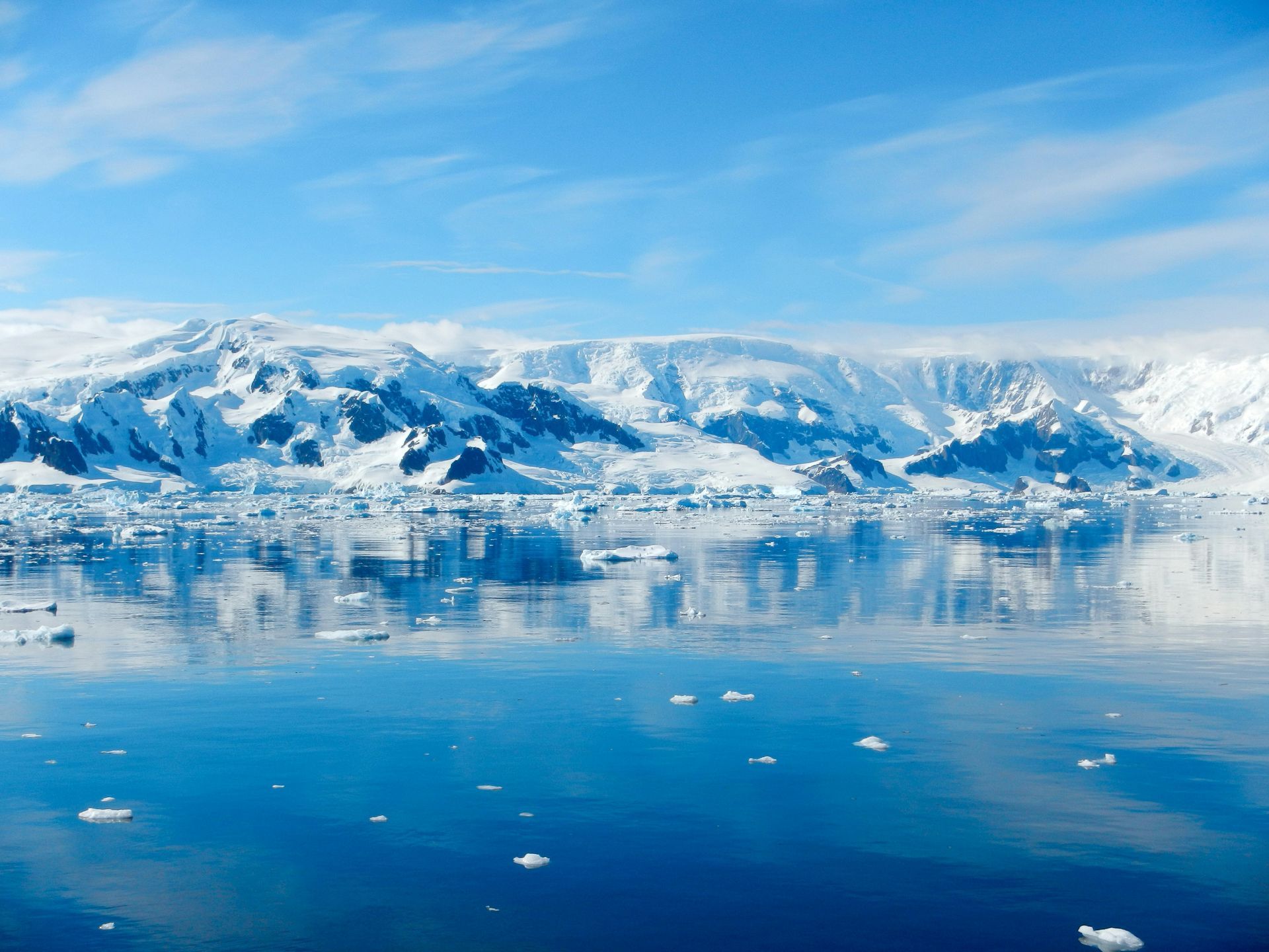 The iceberg has a large archway and is a light blue and white color in Antarctica on HX Expedition Cruise.