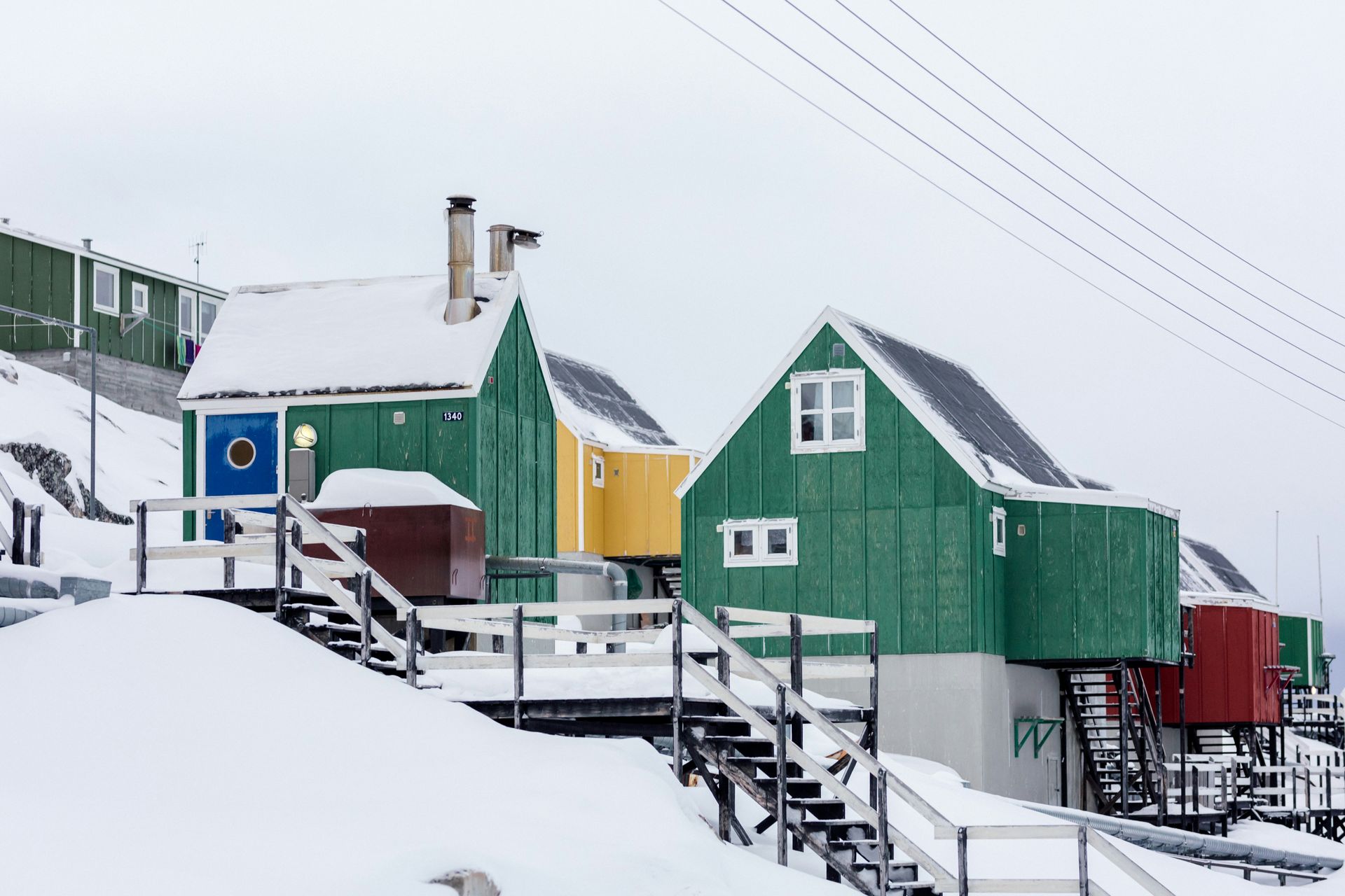 Colorful houses on a snowy hillside in a cold, wintry climate in Aasiaat, Greenland.