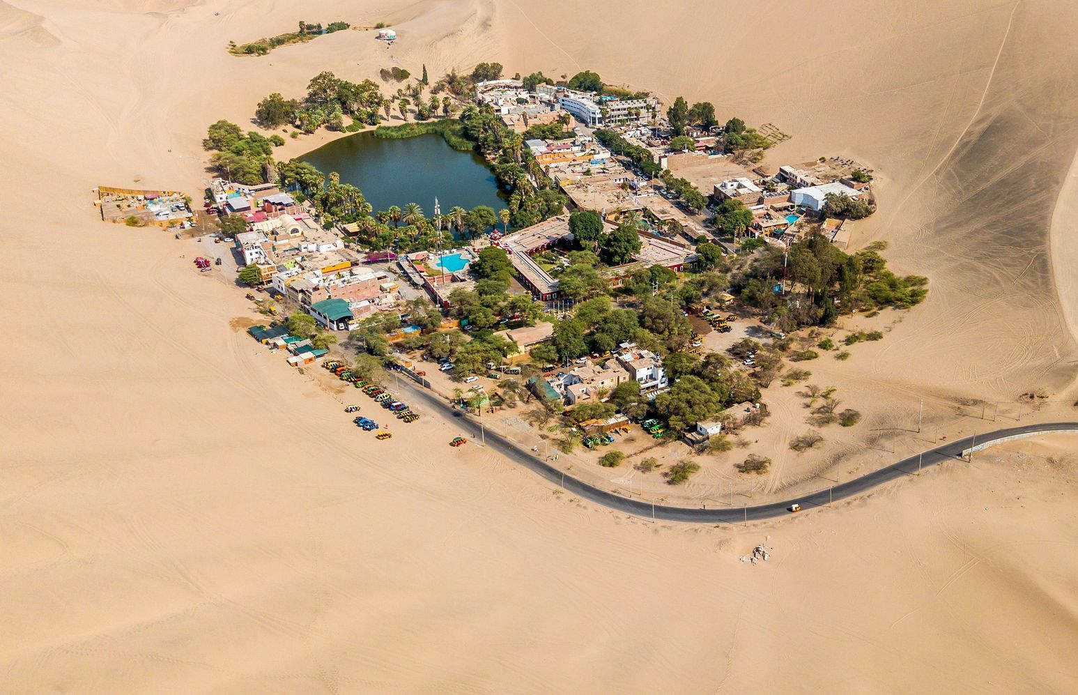 An aerial view of the small village of Huacachina in the middle of a desert in Peru.