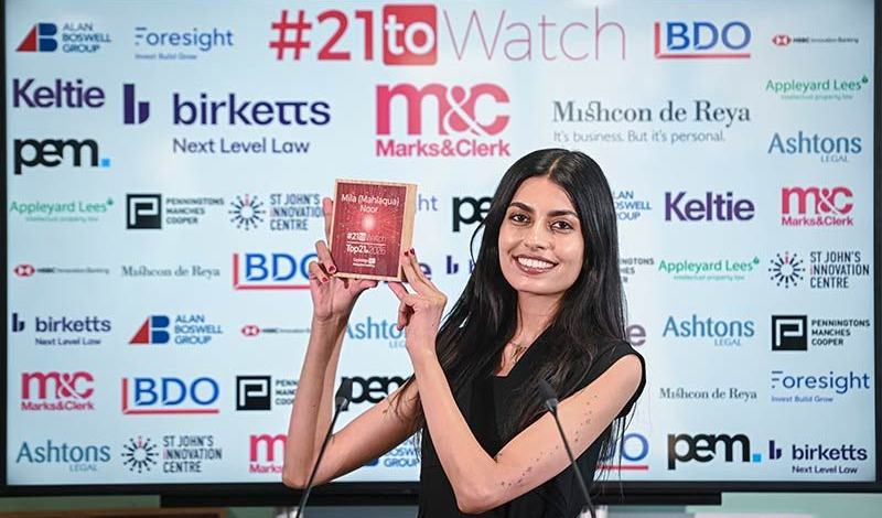 Portrait shot of one of the Top21 #21toWatch winners holding her plaque.