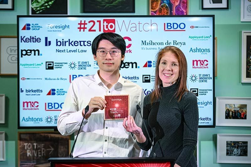 Close up of one of the Top21 #21toWatch winners holding his plaque.