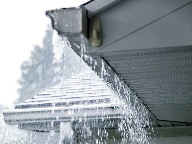 Clean gutters and downspouts directing rainwater away from a custom coastal home in Delaware.