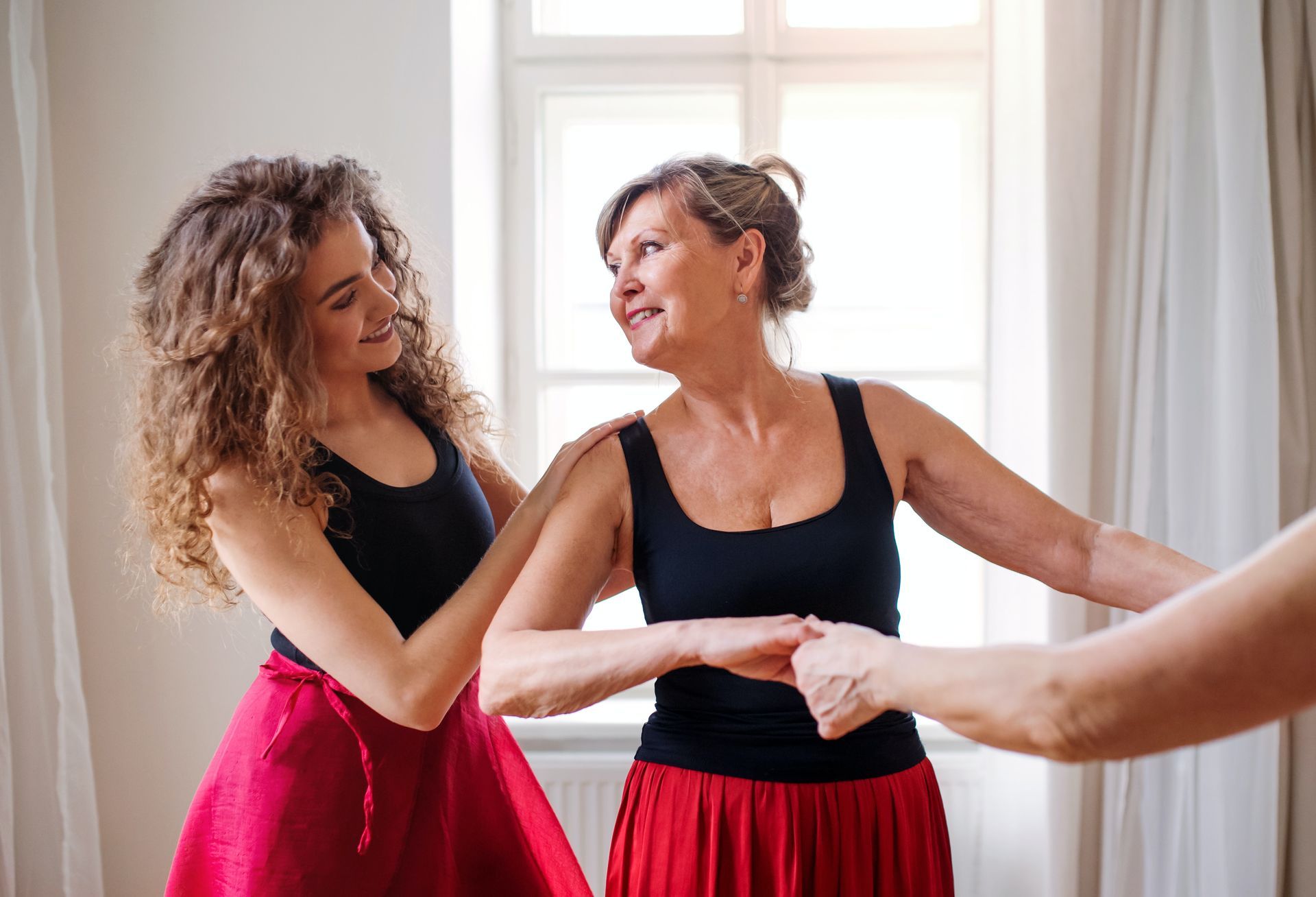 A mother and daughter are dancing together in a room.