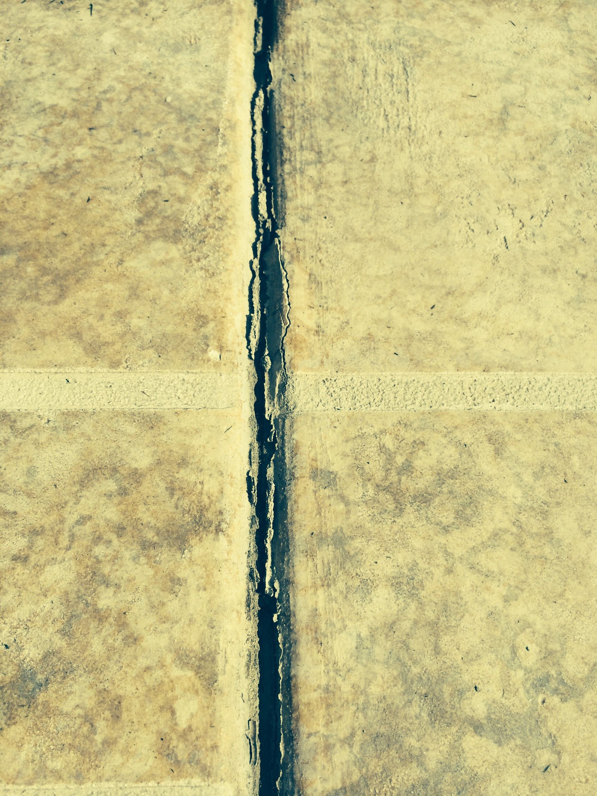 A close up of a concrete wall with a black line in the middle.