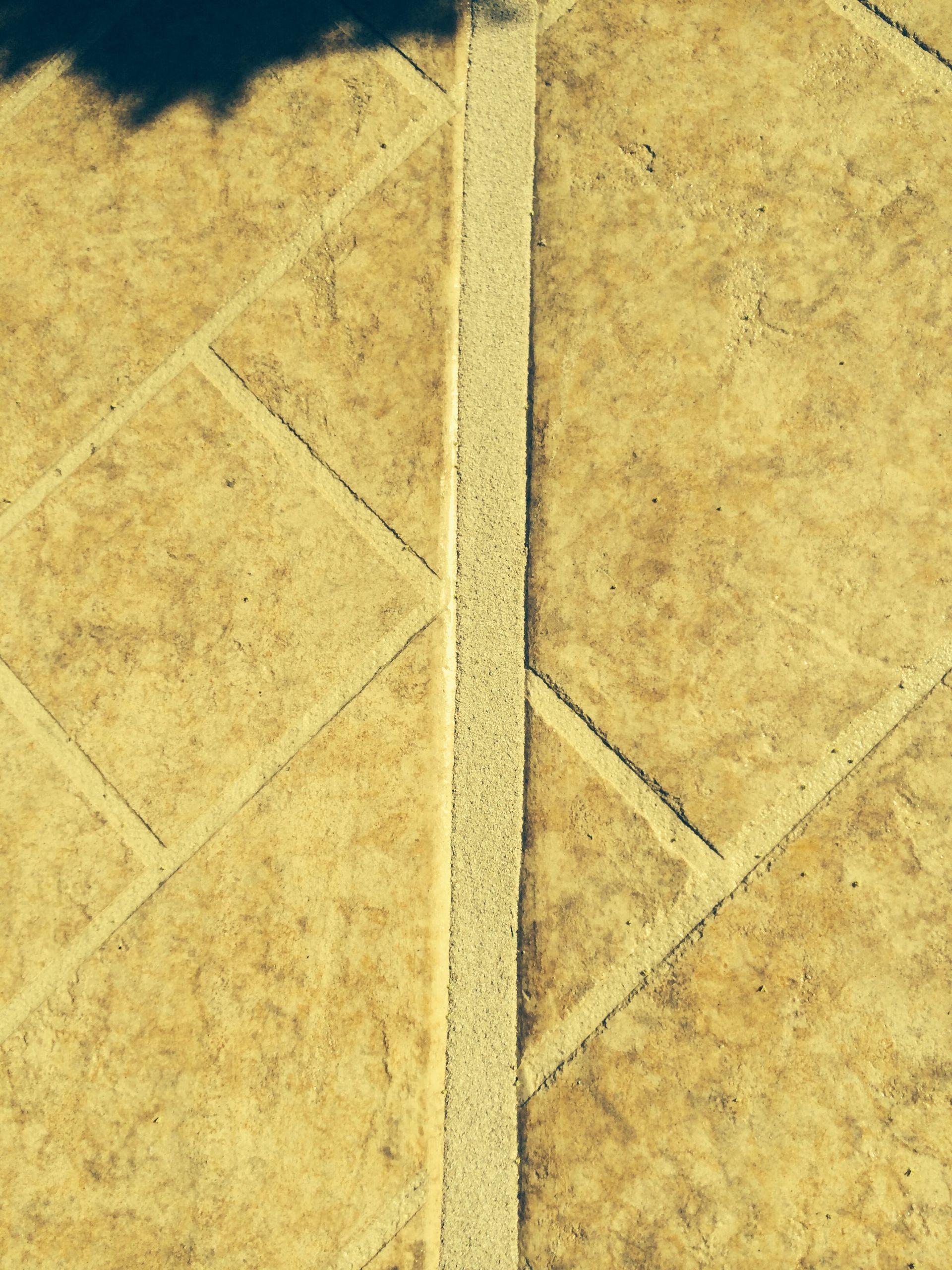 A close up of a tile floor with a white line between the tiles.