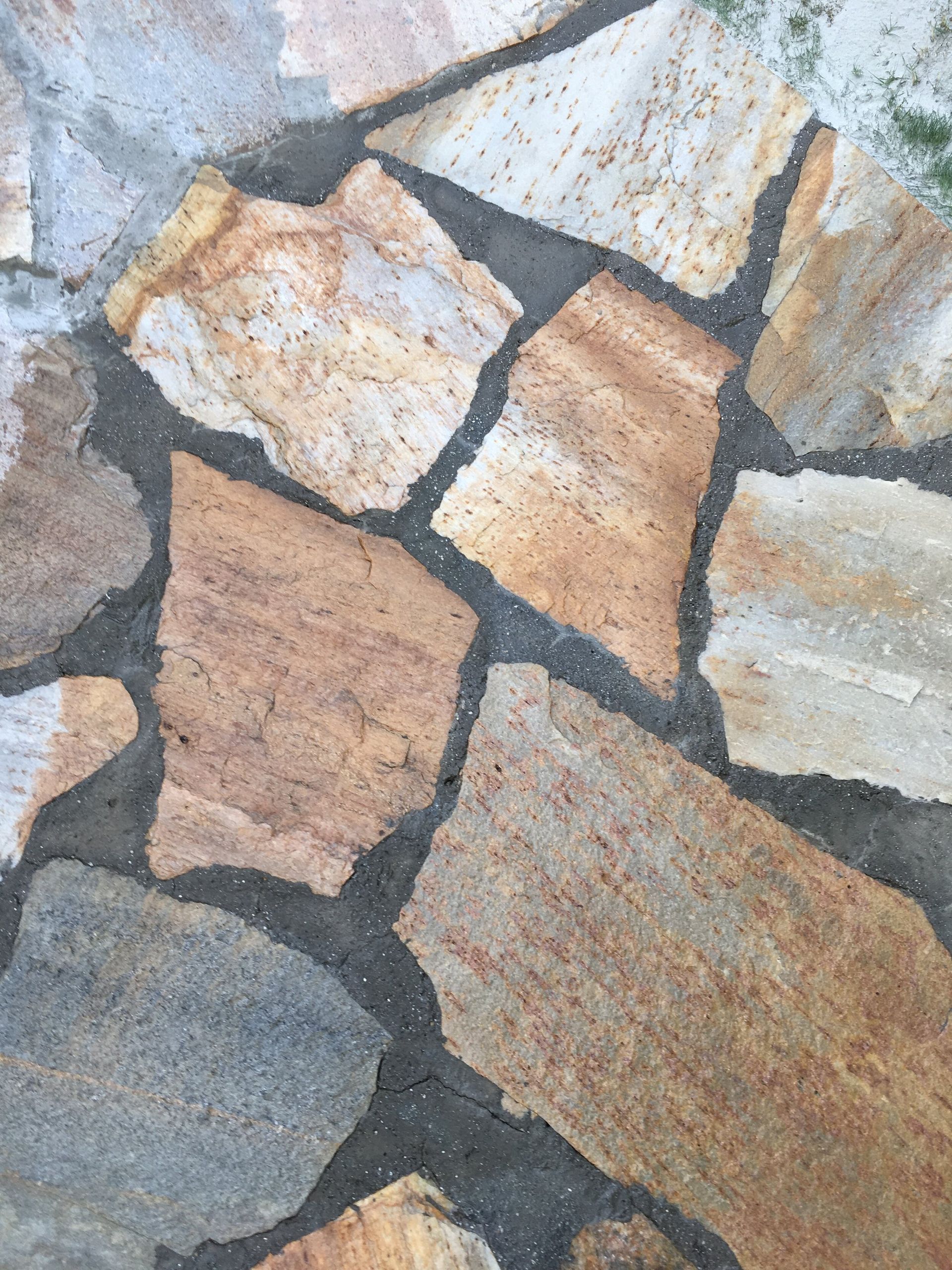 A close up of a stone wall with a few pieces of rocks
