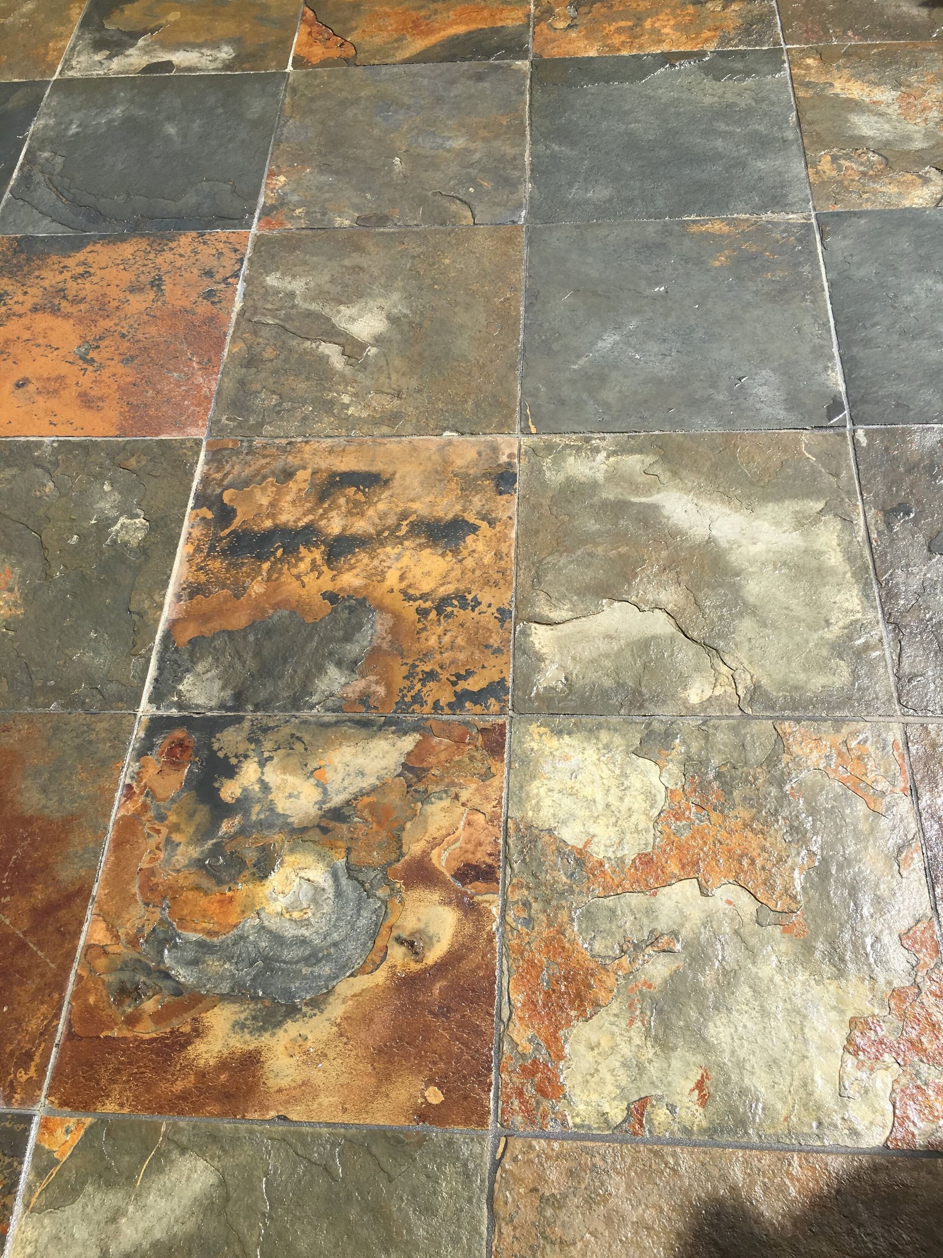 A close up of a tiled floor with a shadow on it