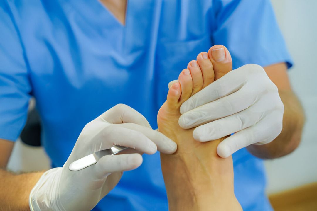 Podiatrist in gloves treating patient’s foot during clinical exam in professional medical setting. Podiatrist in gloves treating patient’s foot during clinical exam in professional medical setting.