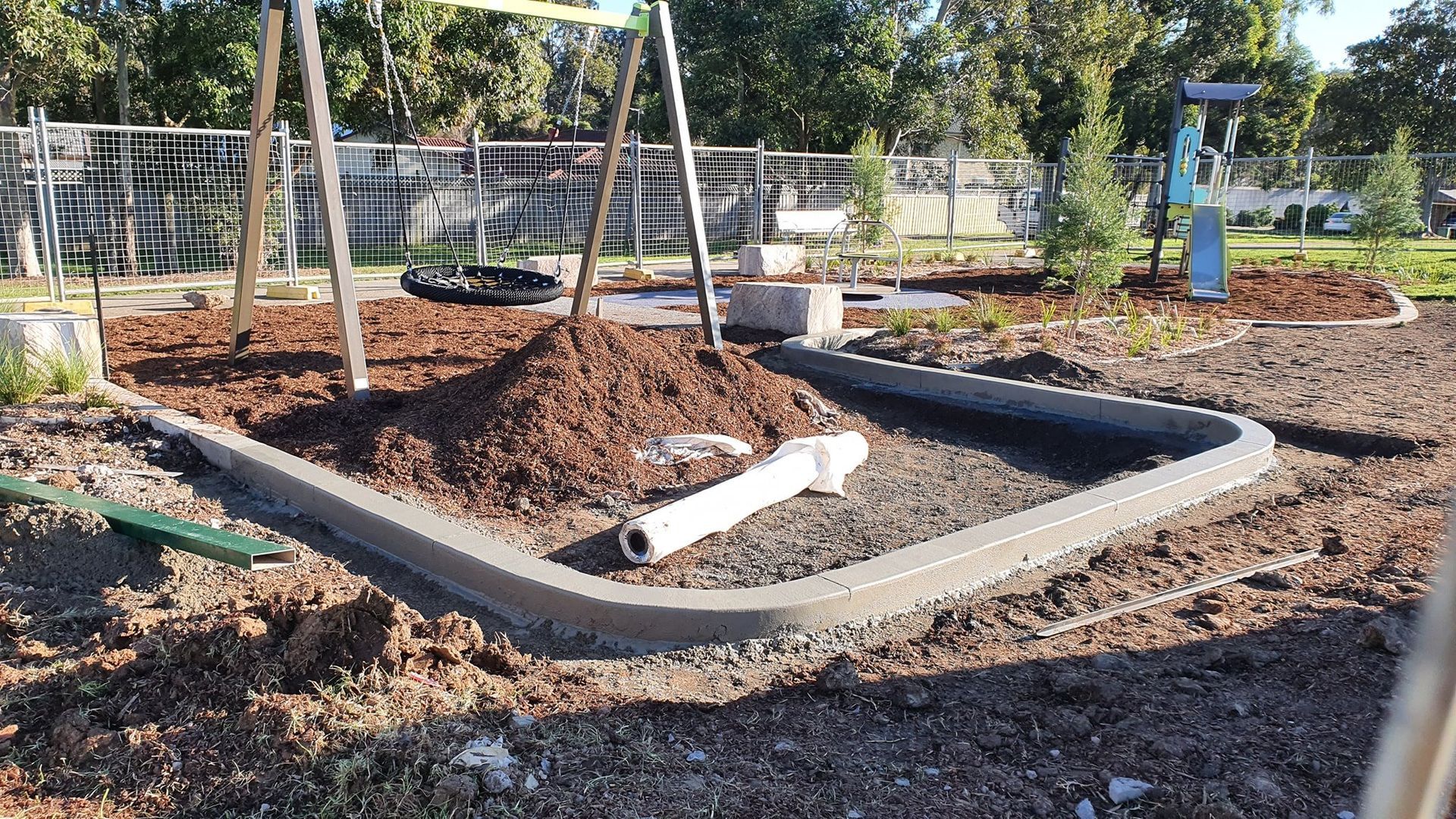 A concrete curb is being built in a park.