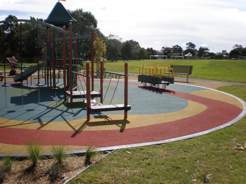 A colorful playground with a bench in the background