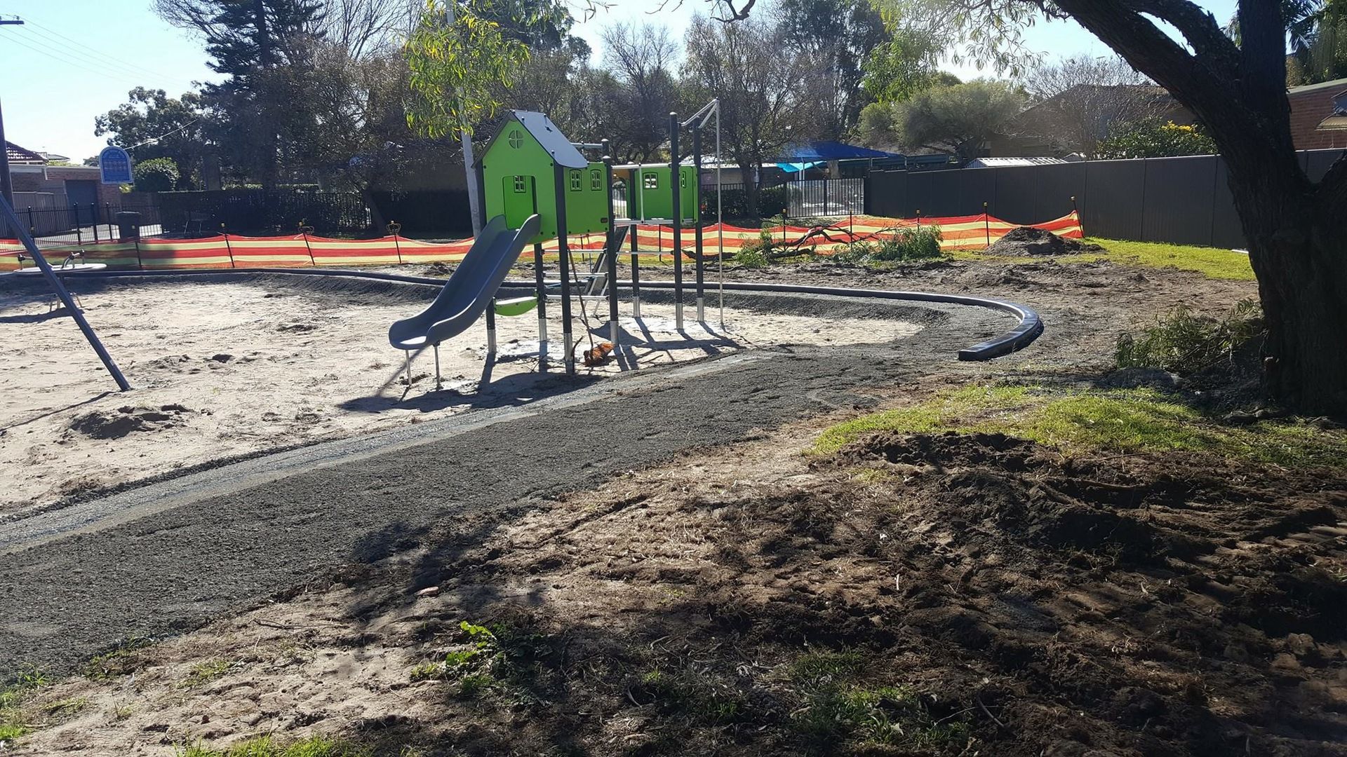A playground with a slide and a house in the middle of it