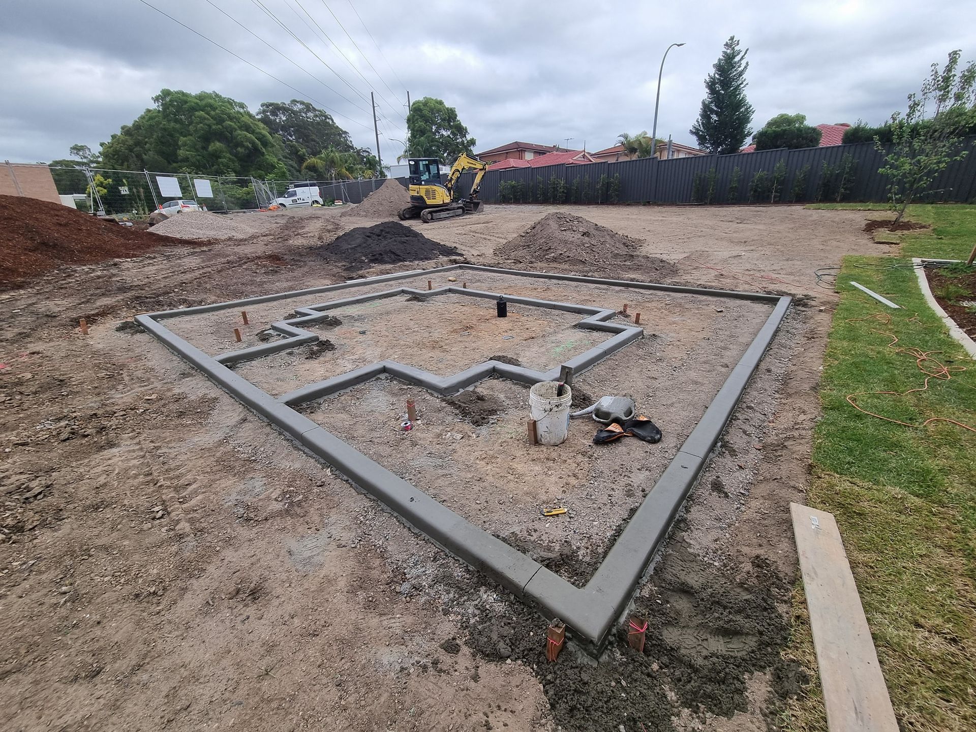 A concrete foundation is being built on a dirt field.