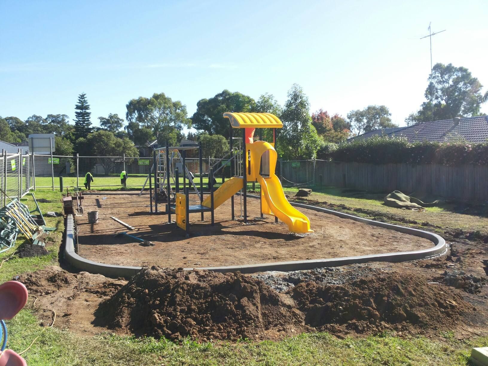 A playground is being built with a yellow slide