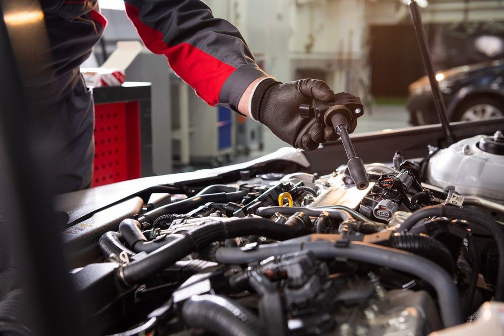 A Mechanic Is Working On A Car Engine In A Garage — Bay City Quality Mobile Mechanic In Pialba, QLD
