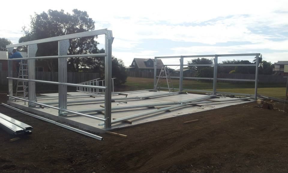 A Metal Structure Is Being Built In A Dirt Field — Bushman Sheds in Bundaberg East, QLD