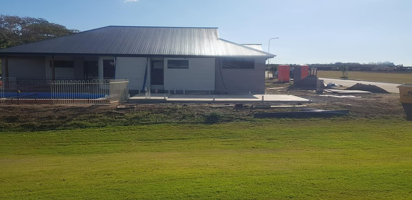 A House Is Being Built In The Middle Of A Grassy Field — Bushman Sheds in Bundaberg East, QLD