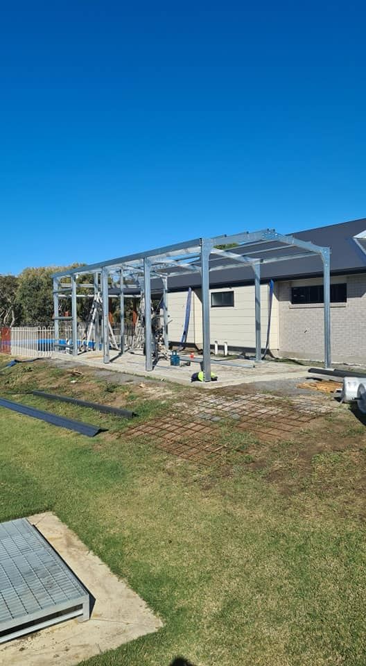 A Metal Structure Is Being Built In Front Of A House — Bushman Sheds in Bundaberg East, QLD