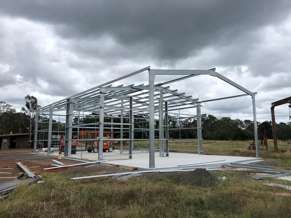 A Large Metal Structure Is Being Built In A Field — Bushman Sheds in South Kolan, QLD