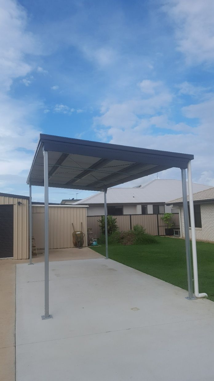 There Is A Carport In The Backyard Of A House — Bushman Sheds in Bundaberg East, QLD