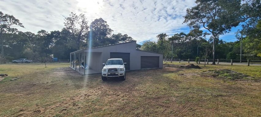 A White Truck Is Parked In Front Of A Shed — Bushman Sheds in Bundaberg East, QLD