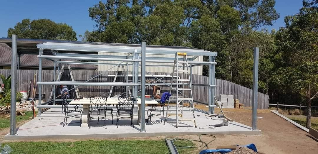A Metal Structure Is Being Built In The Backyard Of A House — Bushman Sheds in Bundaberg East, QLD