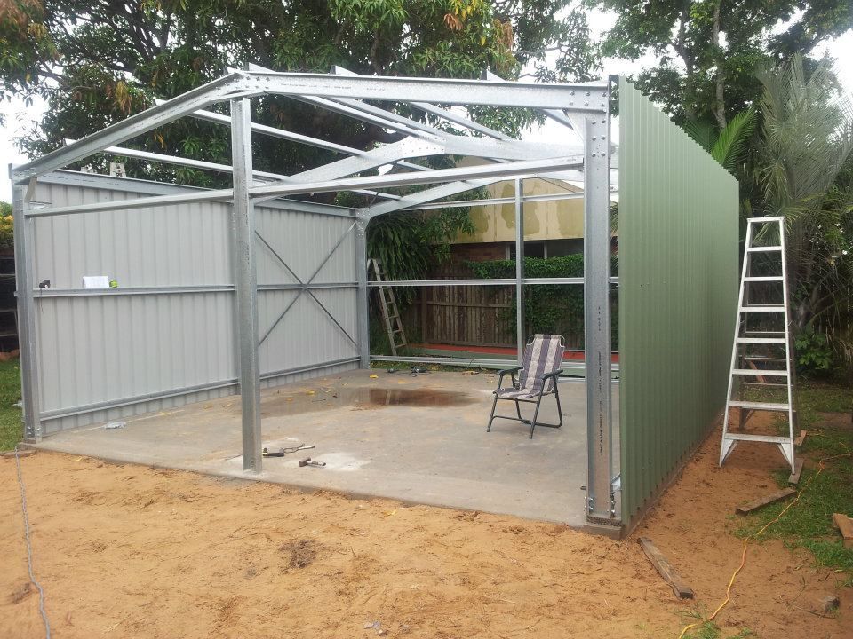 A Shed Is Being Built In A Backyard With A Chair And Ladder — Bushman Sheds in Bundaberg East, QLD