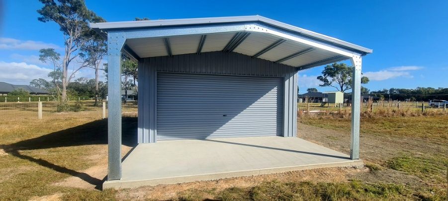 A Metal Garage With A Concrete Floor Is Sitting In The Middle Of A Field — Bushman Sheds in Bundaberg East, QLD