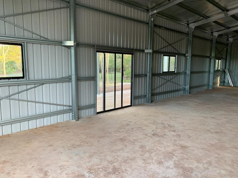 A Large Empty Shed With A Lot Of Windows And Doors — Bushman Sheds in Bundaberg East, QLD
