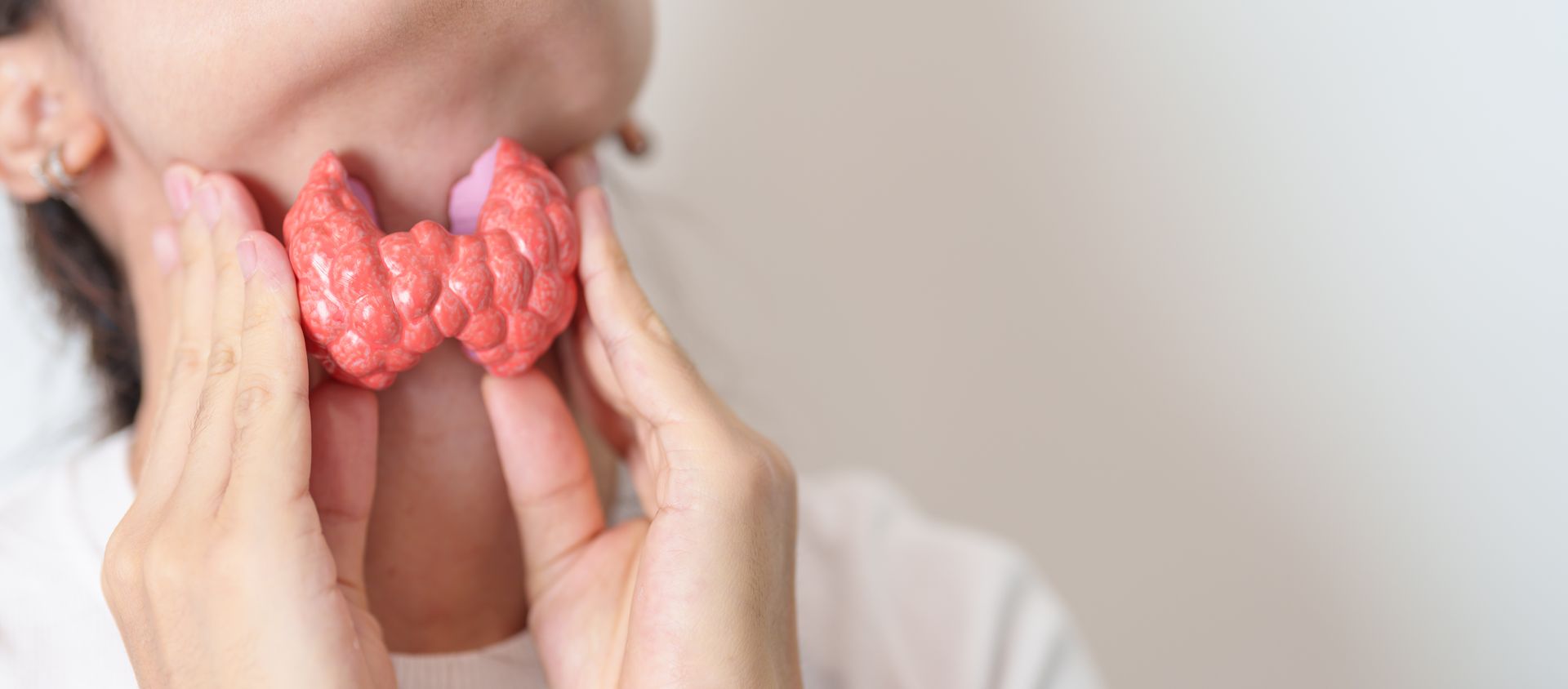 Cirurgião de cabeça e pescoço realizando tireoidectomia com monitoramento de nervos e preservação das glândulas paratireoides.