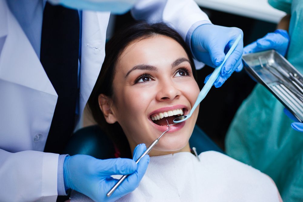 Woman Attends Dental Check Up Dentist Examines Her Teeth
