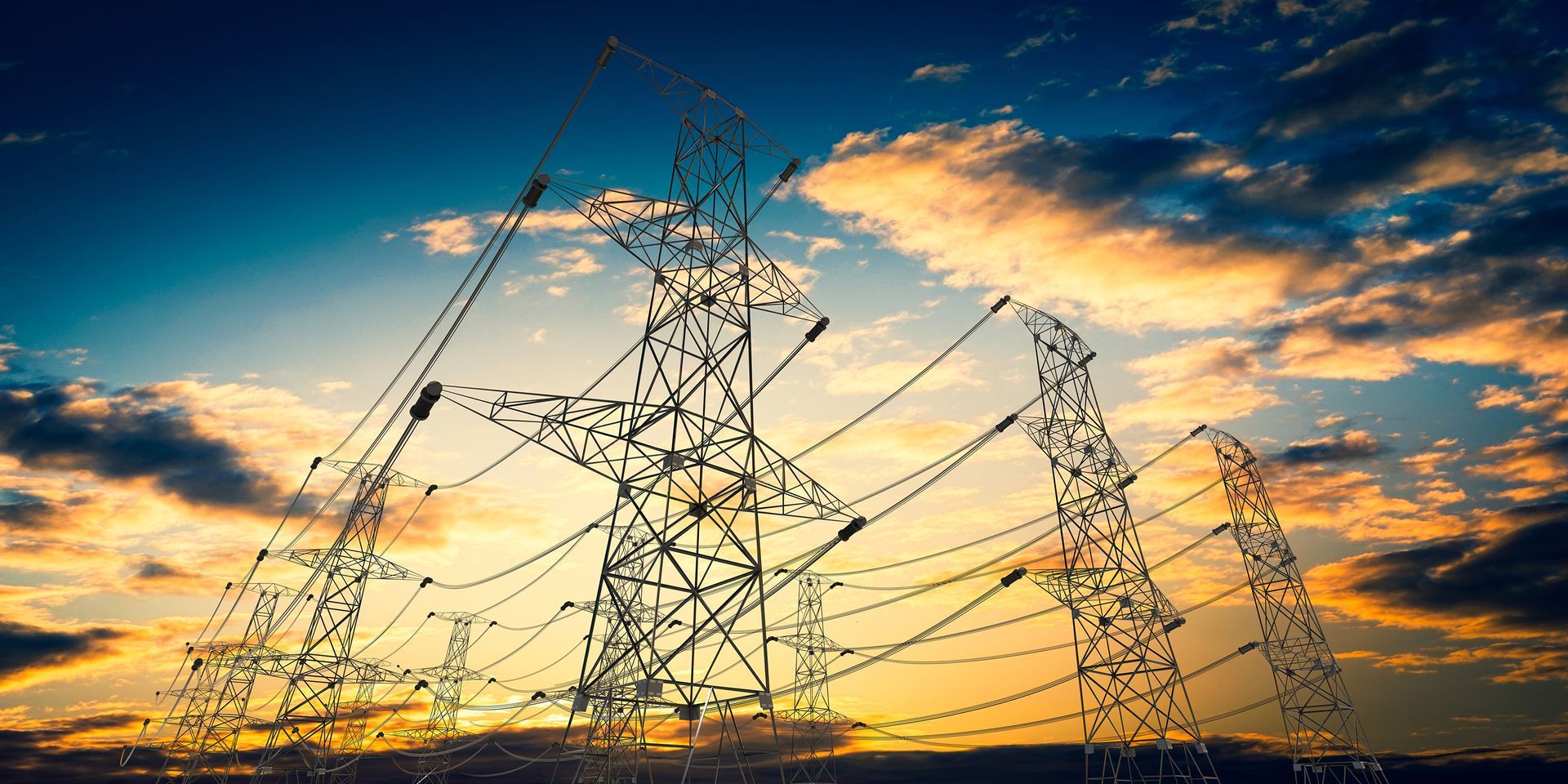Power lines and towers against a colorful sunset sky.