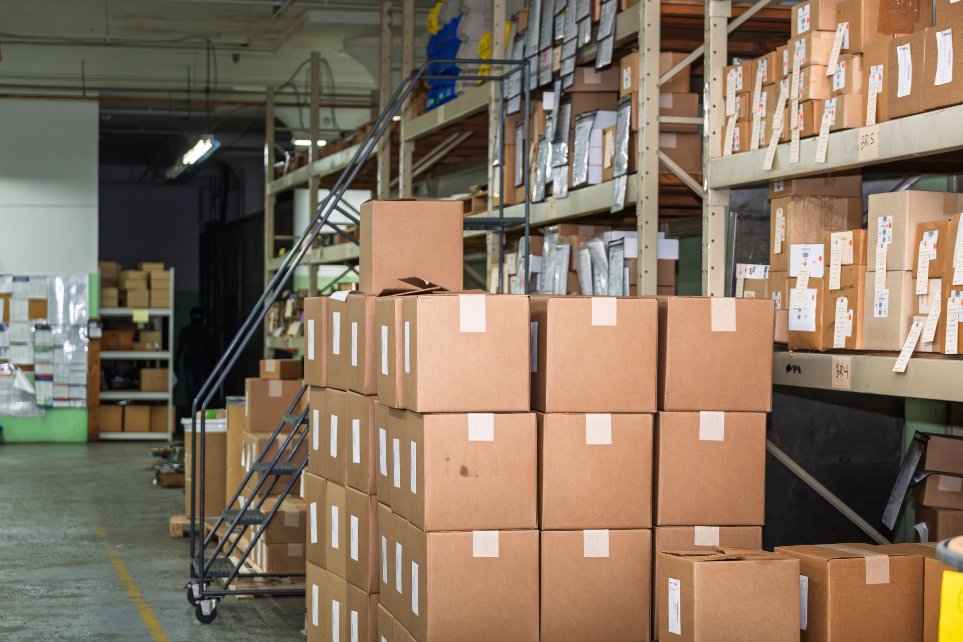 Warehouse interior with stacked cardboard boxes and shelving.