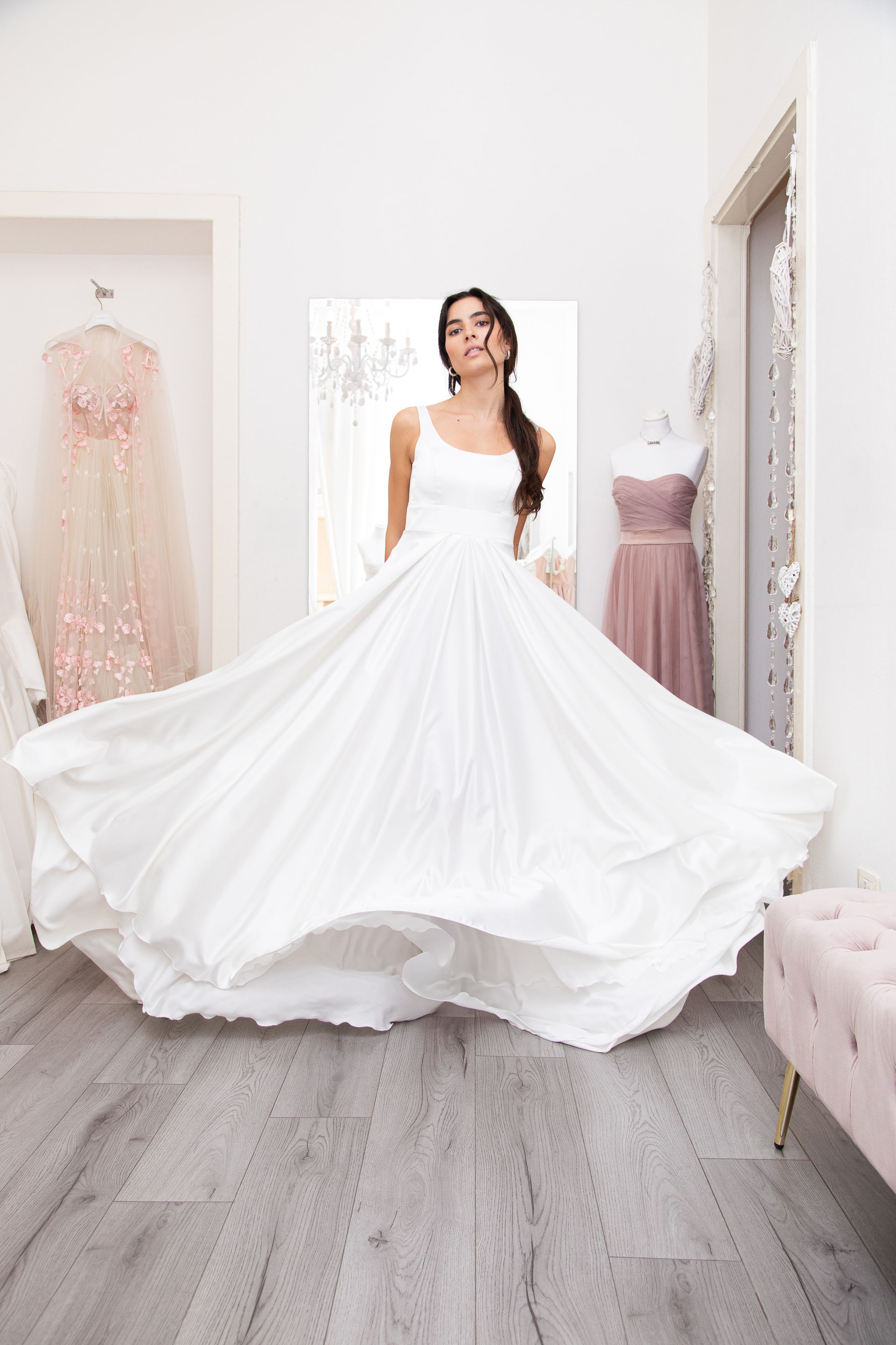Una donna in abito da sposa bianco è in piedi in una stanza.