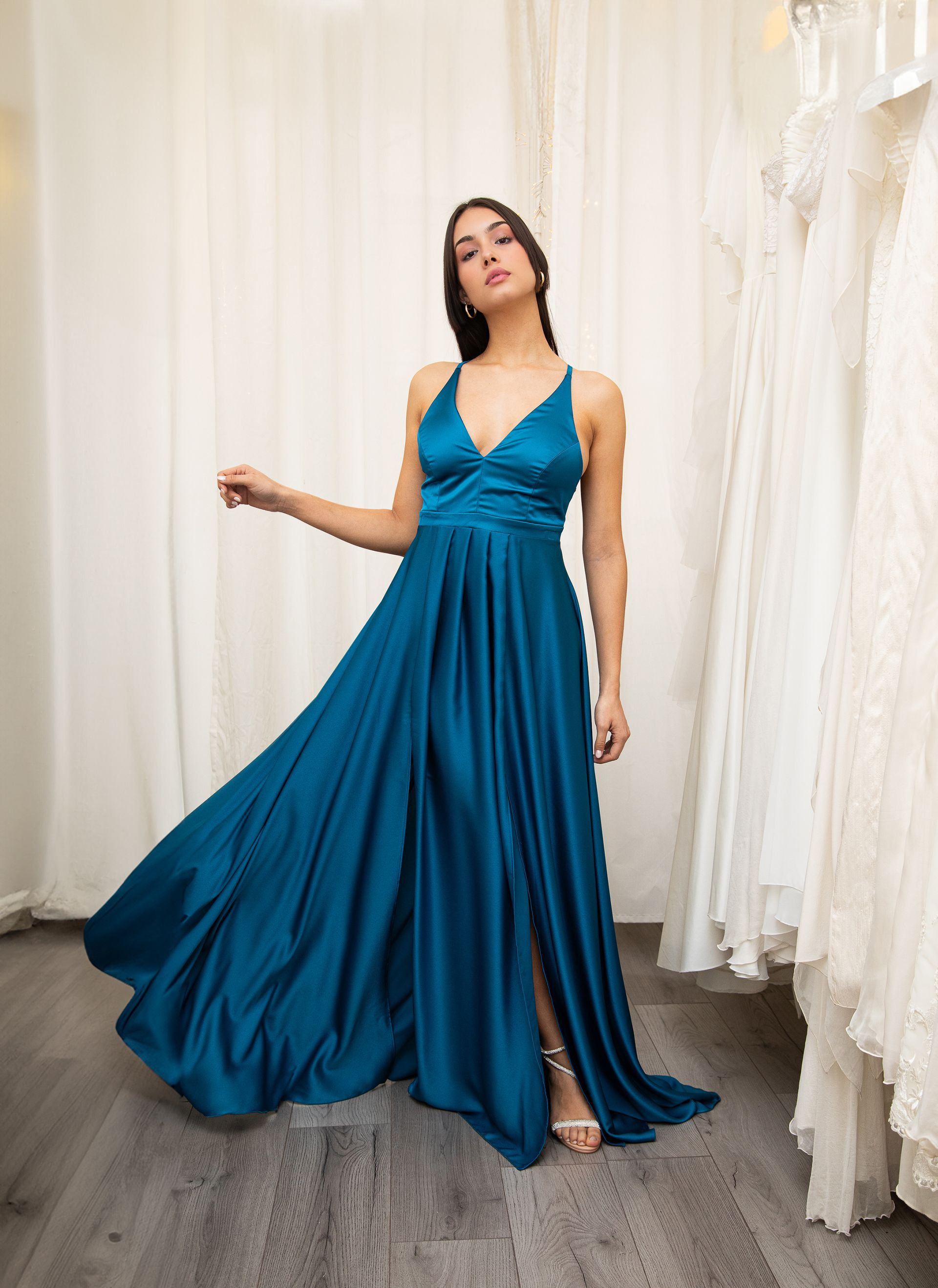 Una donna con un lungo abito blu è in piedi in una stanza.