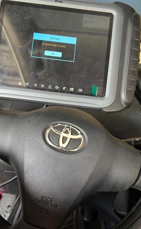 Toyota steering wheel with a mounted screen showing a small pop-up dialog in a vehicle interior.