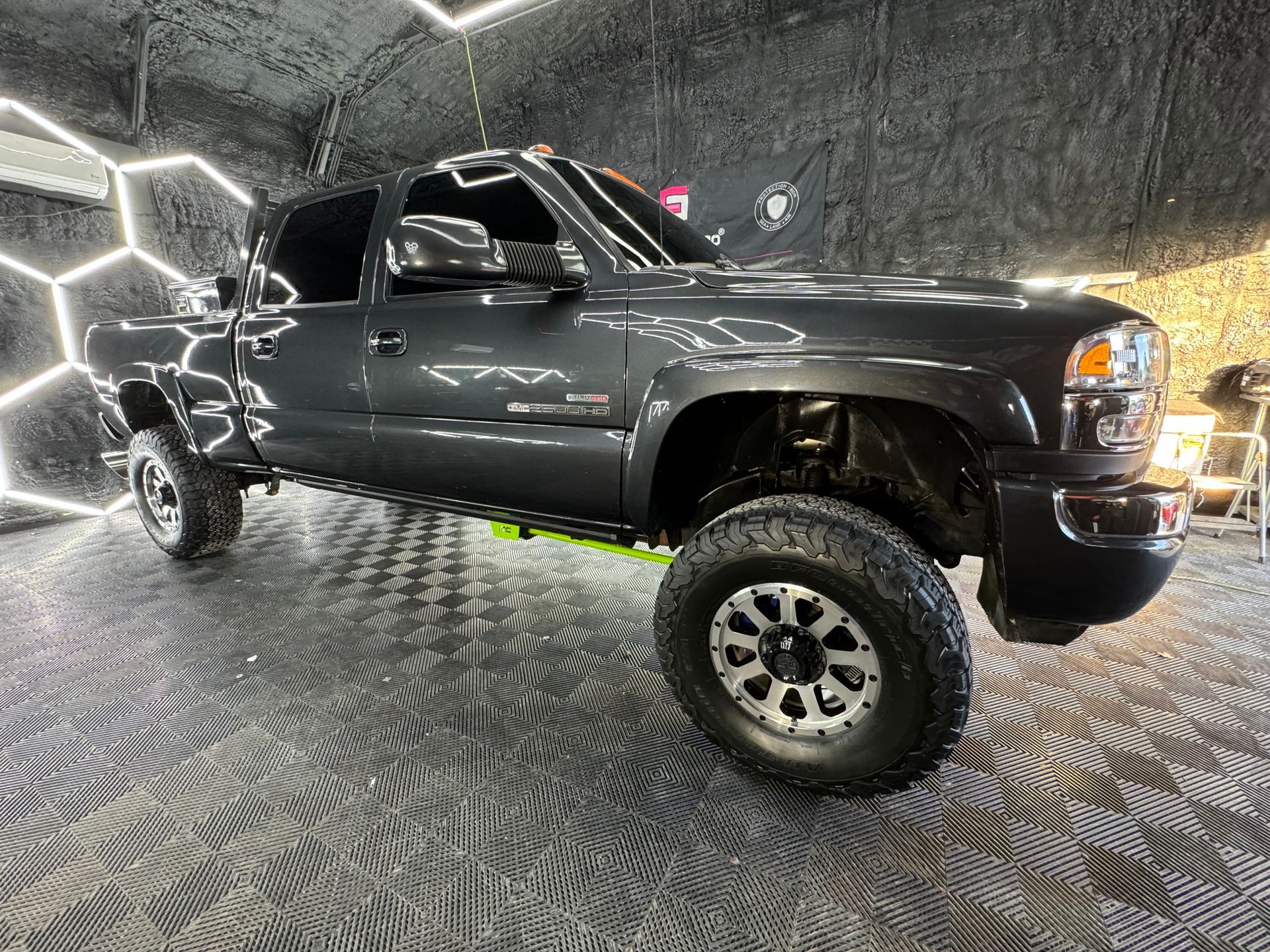 A black pickup truck is parked in a garage.