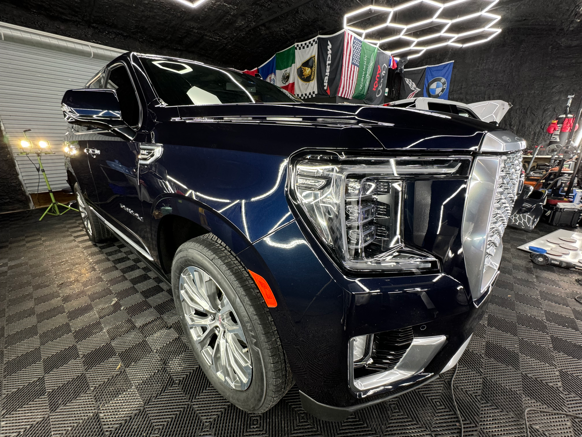 A blue gmc yukon is parked in a garage.