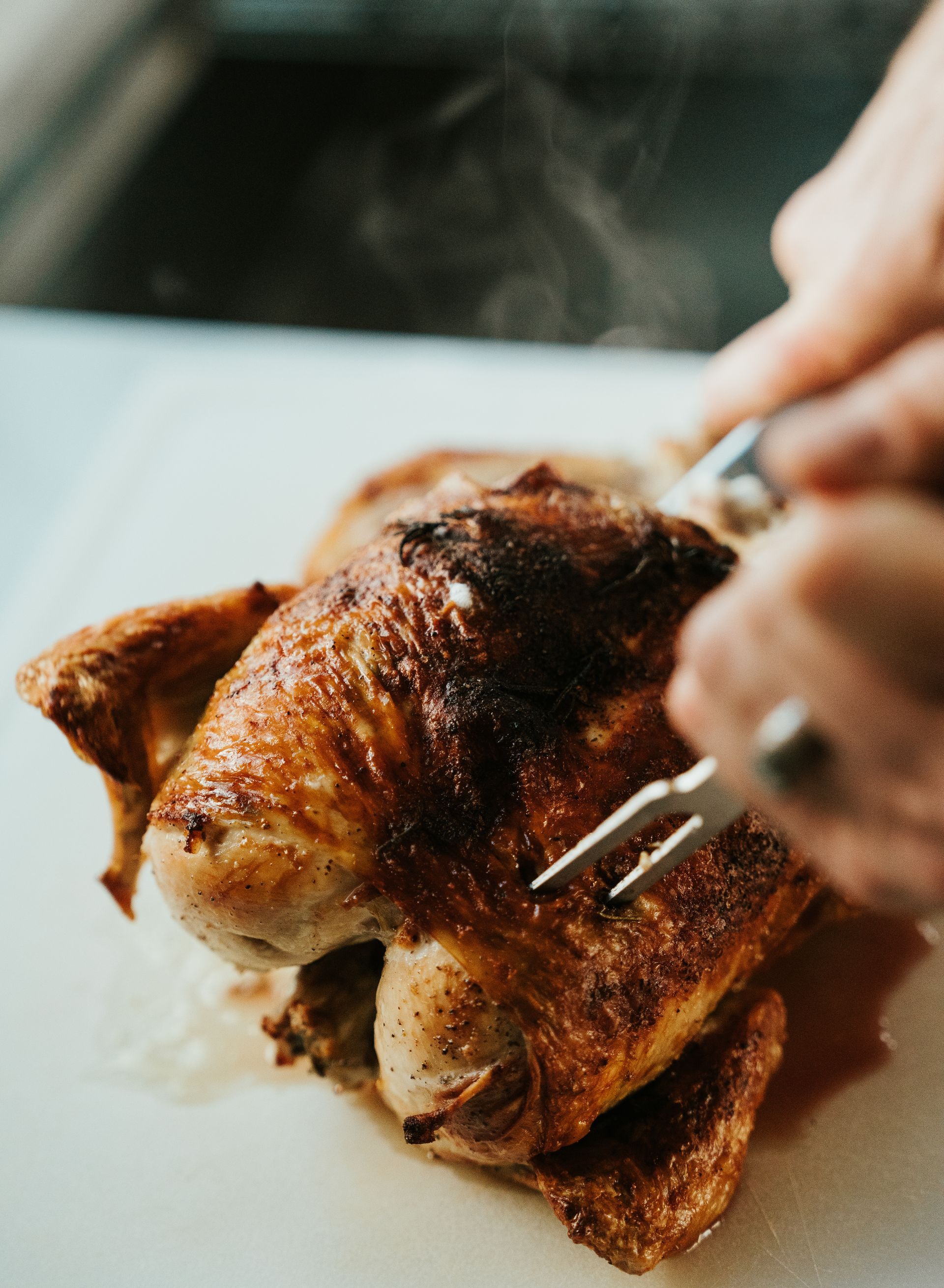 Roast chicken being cut up with skewers for service.