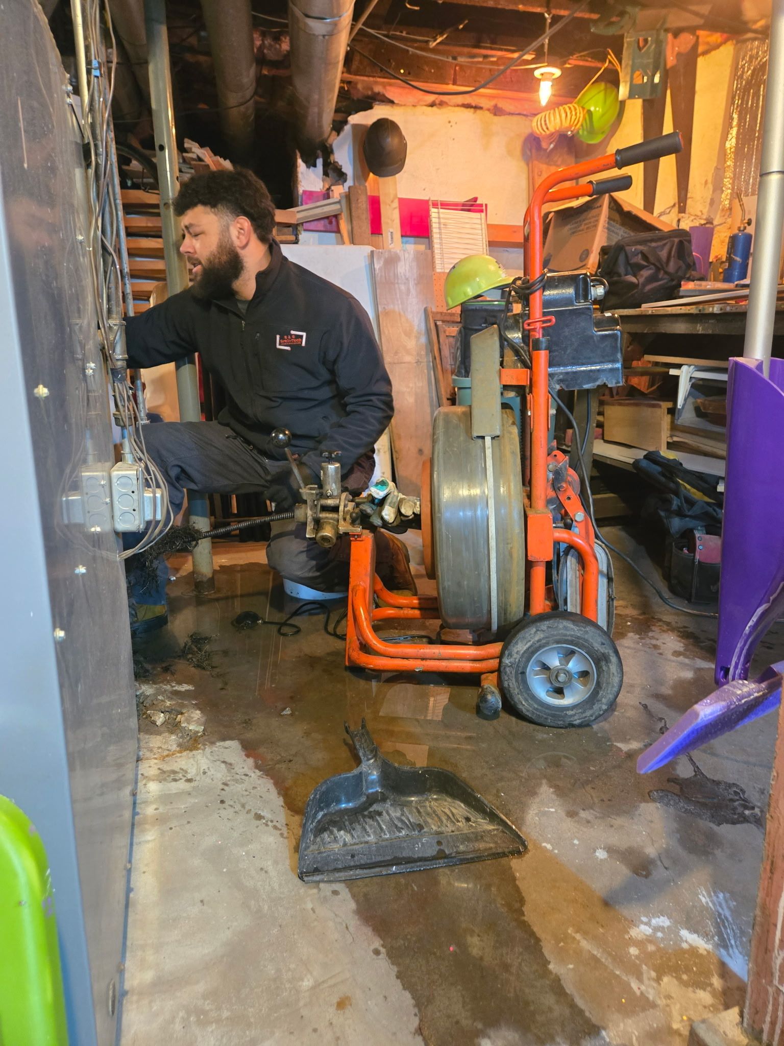 A man is working on a machine in a basement.