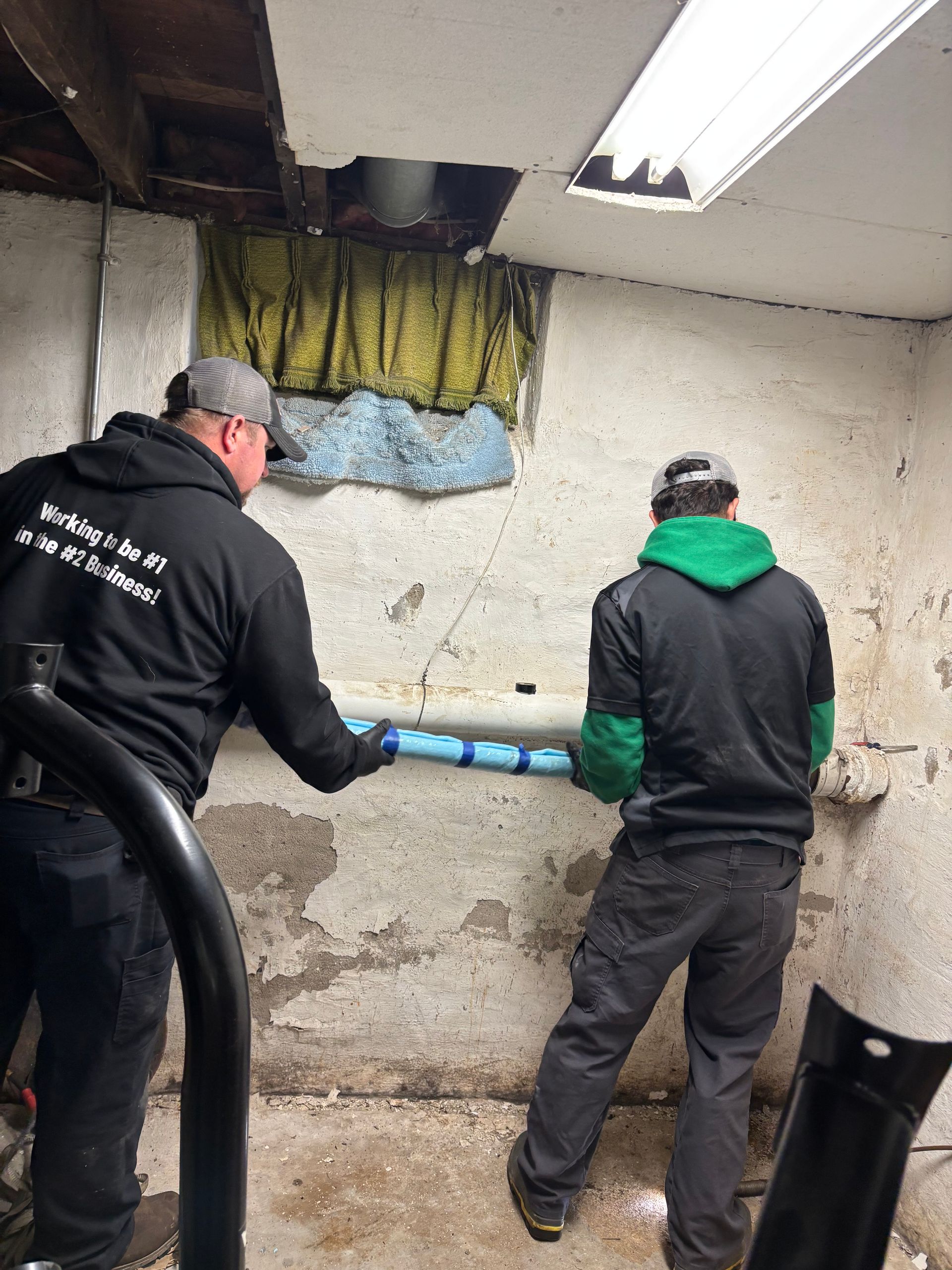 Blue water pipe repairs in a dirt trench with clamps and exposed soil sides