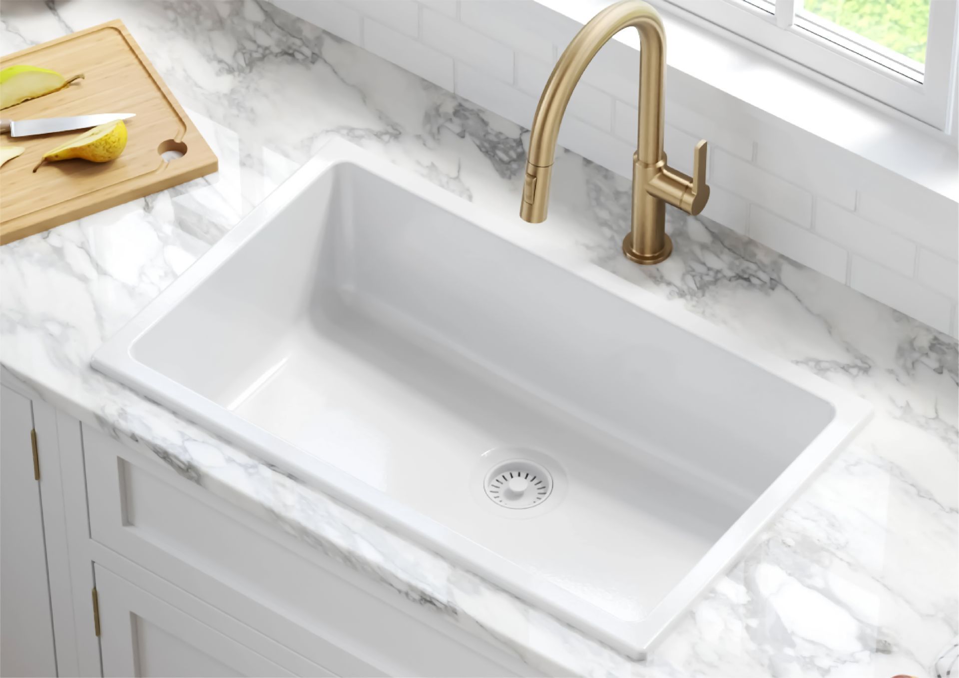 White farmhouse kitchen sink with gold faucet on a marble countertop