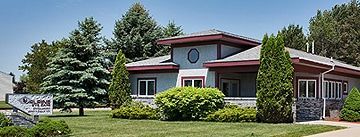 A large house with a lot of windows and trees in front of it.