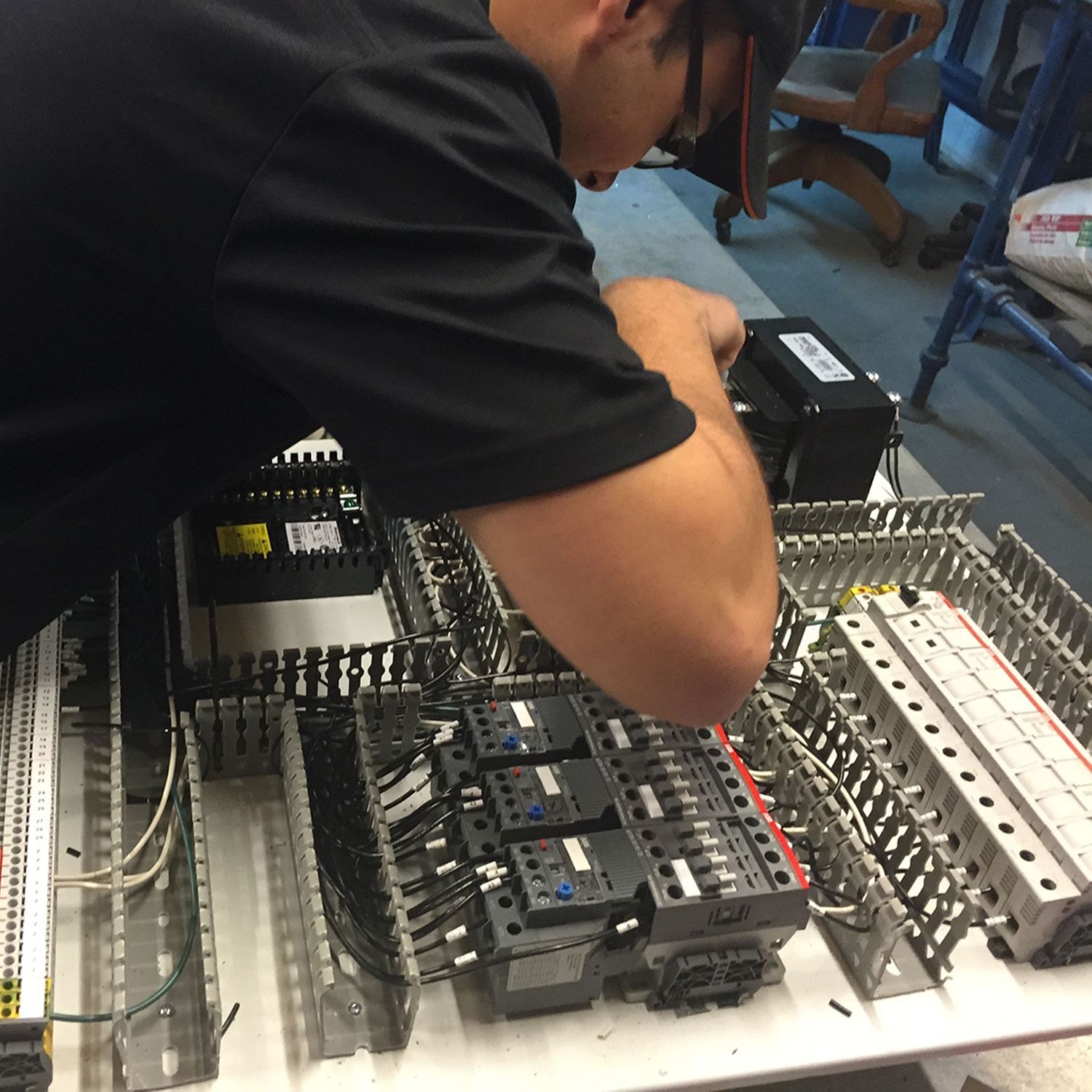 A man in a black shirt is working on a circuit board
