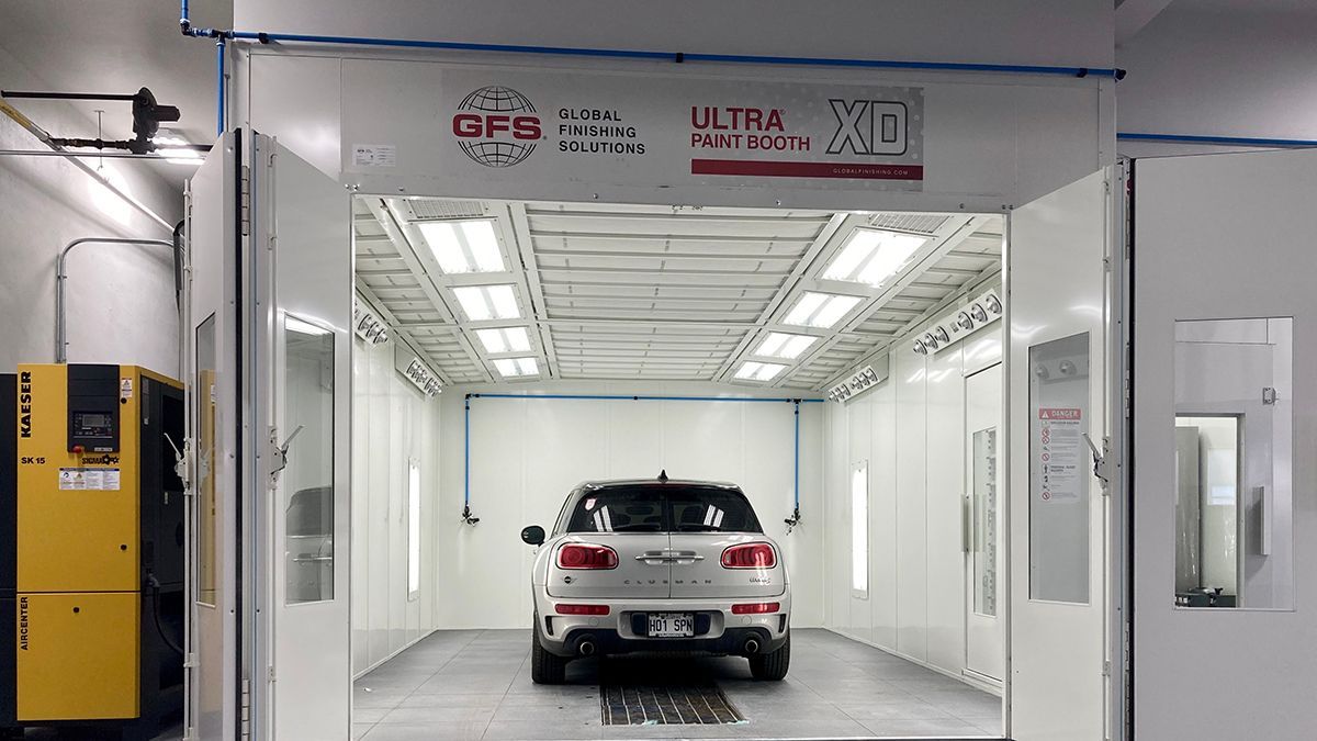 A car is sitting inside of a paint booth.