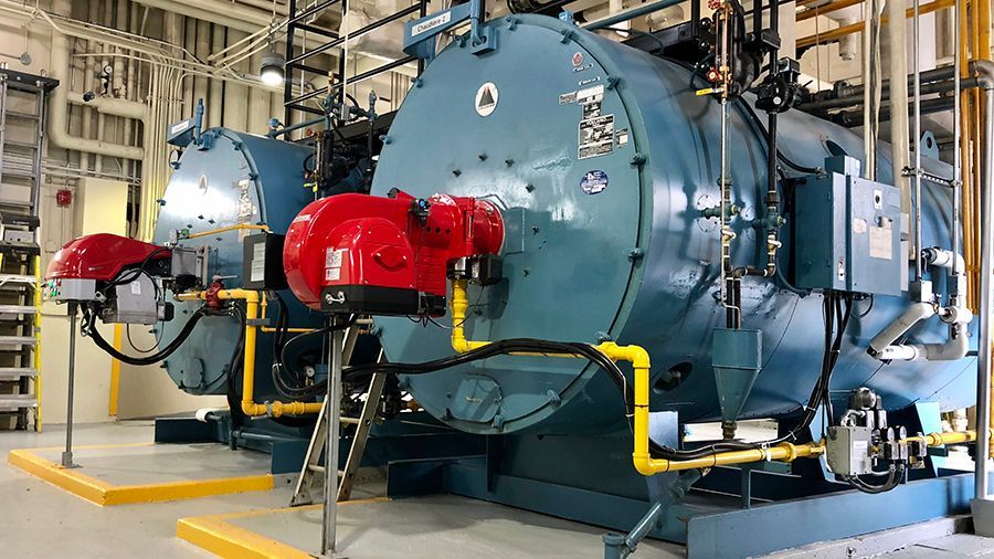 A group of boilers are sitting next to each other in a factory.